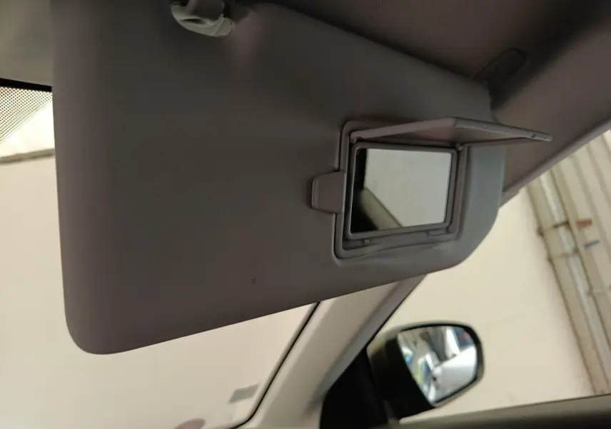 Miroir de courtoisie ouvert sur pare-soleil intérieur gris clair du Peugeot 5008, vue côté conducteur avec rétroviseur extérieur visible.