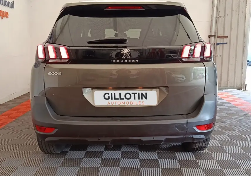 Vue arrière d'un Peugeot 5008 gris foncé avec feux LED distinctifs et logo au centre du hayon.
