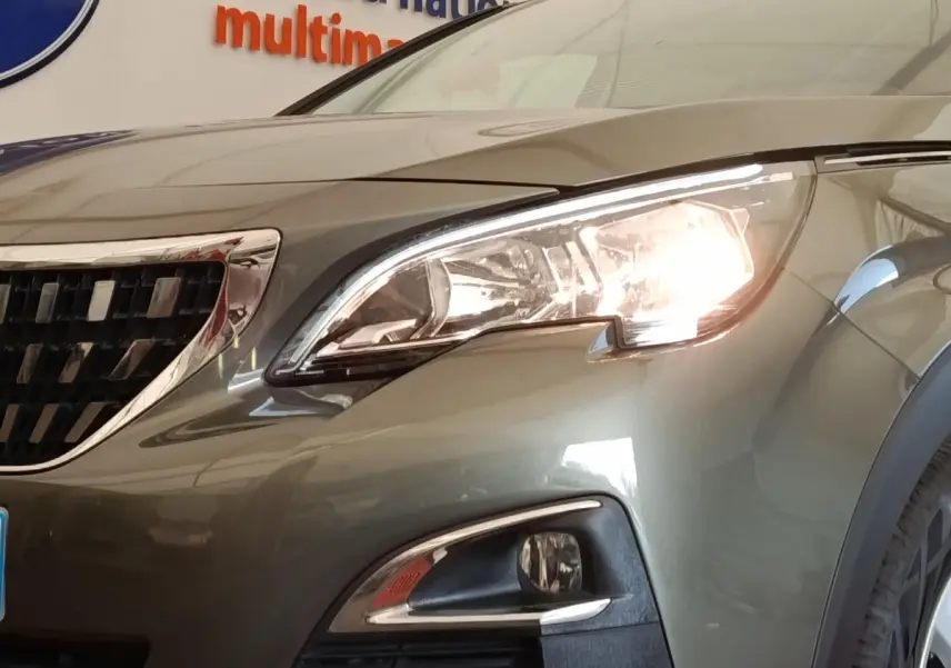 Gros plan sur l'avant droit gris foncé du Peugeot 5008 2020 avec phare allumé et calandre chromée.