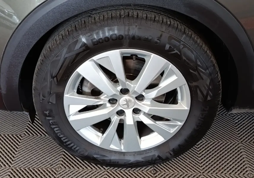 Gros plan sur la roue avant droite du Peugeot 5008 gris foncé, avec jante alliage et pneu Continental EcoContact 6.