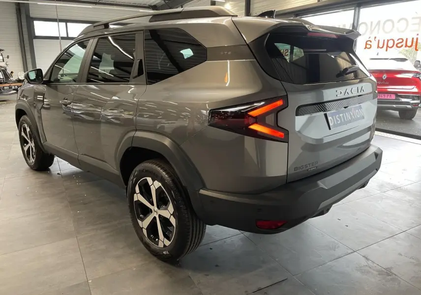 Vue 3/4 arrière droite du Dacia Bigster gris schiste avec feux arrière LED en forme de flèche et jantes alliage diamantées.
