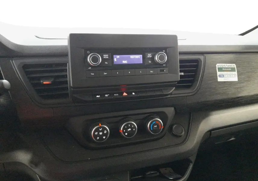Vue rapprochée du tableau de bord noir du Renault Trafic Fourgon 2024 avec commandes climatisation et radio intégrée.