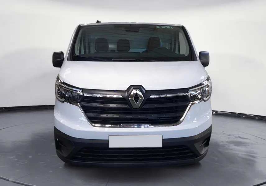Vue frontale d’un Renault Trafic Fourgon blanc minéral 2024 avec calandre noire et logo Renault central bien visible.
