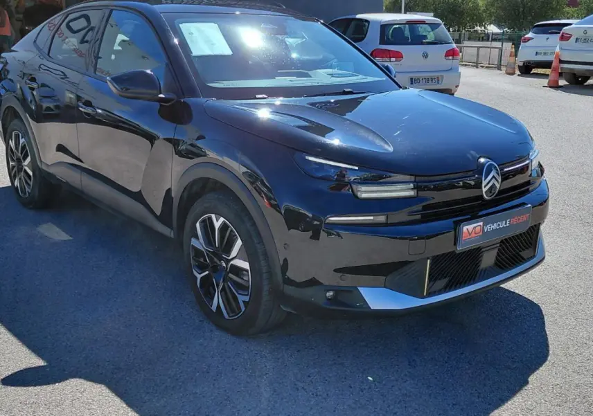 Vue 3/4 avant droite d'une Citroën C4 X noire 2025 avec jantes alliage 17 pouces et toit ouvrant panoramique.