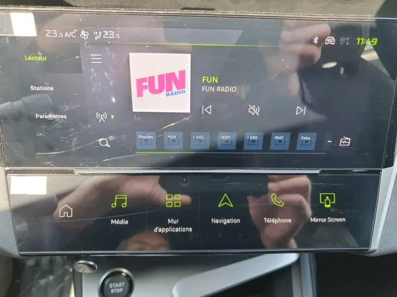 Écran tactile central de la Peugeot 308 blanc Okénite, affichant la radio FUN en interface multimédia moderne.