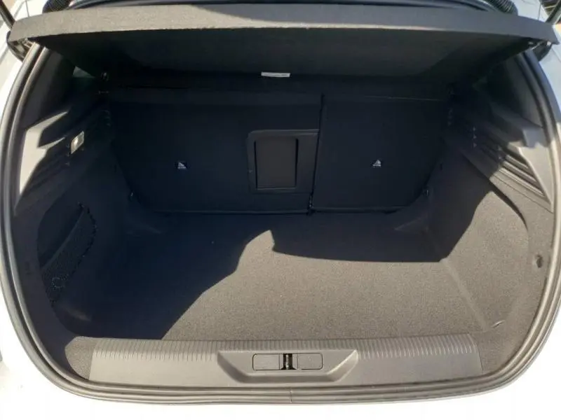 Coffre ouvert vu de l'arrière d'une Peugeot 308 blanche, montrant un espace de chargement propre et spacieux.