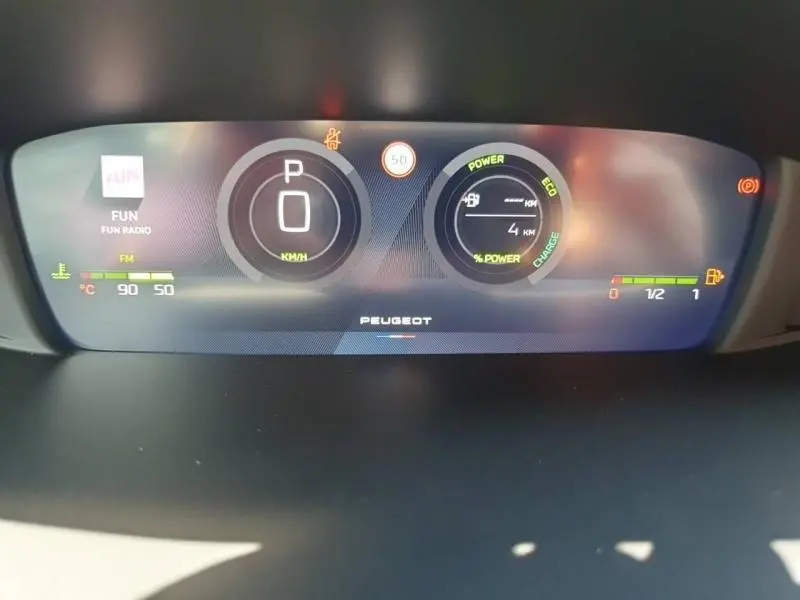 Tableau de bord numérique de Peugeot 308 Hybrid 2026 affichant vitesse, autonomie, et indicateurs de puissance en vue frontale.