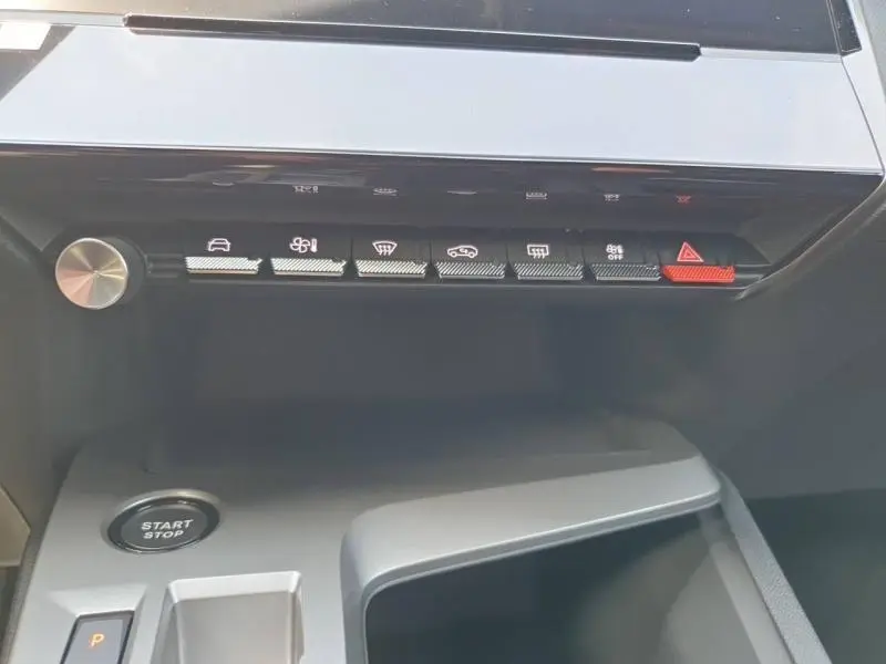 Vue rapprochée de la console centrale de la Peugeot 308 Hybrid 2026 avec boutons de commande et bouton Start/Stop.