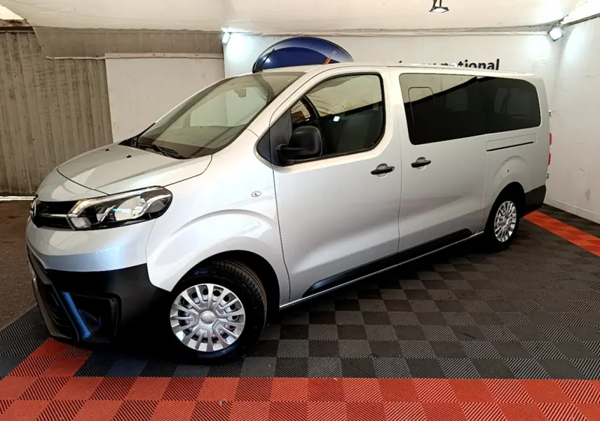 Vue côté droit 3/4 avant d'un Toyota Proace Verso gris clair avec vitres arrière teintées et jantes acier.