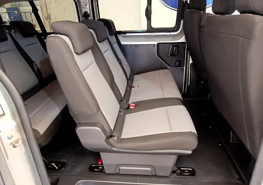 Vue latérale intérieure des sièges arrière gris clair et foncé du Toyota Proace Verso 2019, avec portière ouverte.