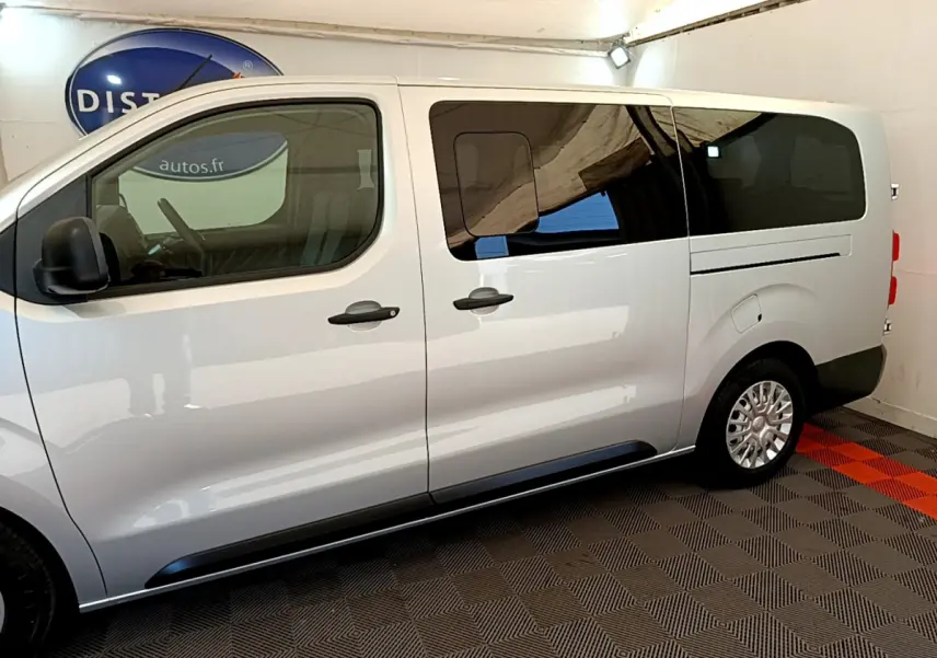 Profil côté gauche du Toyota Proace Verso gris clair 2019 avec vitres arrière teintées et jantes alliage.
