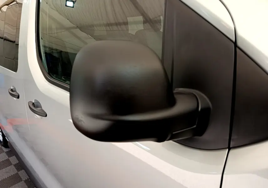 Gros plan sur le rétroviseur noir côté droit d’un Toyota Proace Verso gris clair, vue latérale avant.