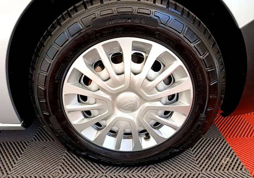 Gros plan sur la roue avant droite du Toyota Proace Verso gris clair, avec jante acier et enjoliveur d'origine.