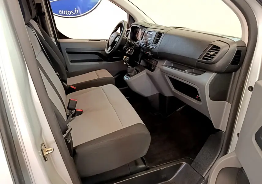 Intérieur avant du Toyota Proace Verso gris clair, vue côté conducteur avec tableau de bord et sièges tissu bicolore.