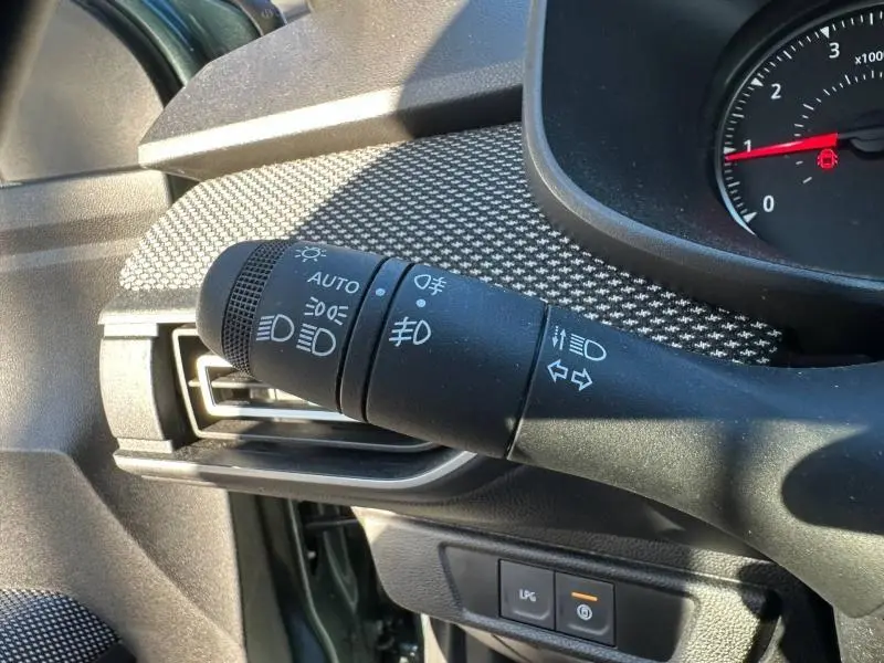 Gros plan sur la commande des feux et clignotants côté gauche du tableau de bord du Dacia Jogger vert Cèdre métallisé.