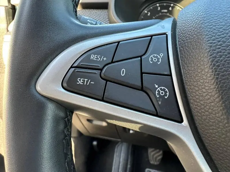 Gros plan sur les commandes du régulateur de vitesse au volant du Dacia Jogger 2025, intérieur noir et argenté.