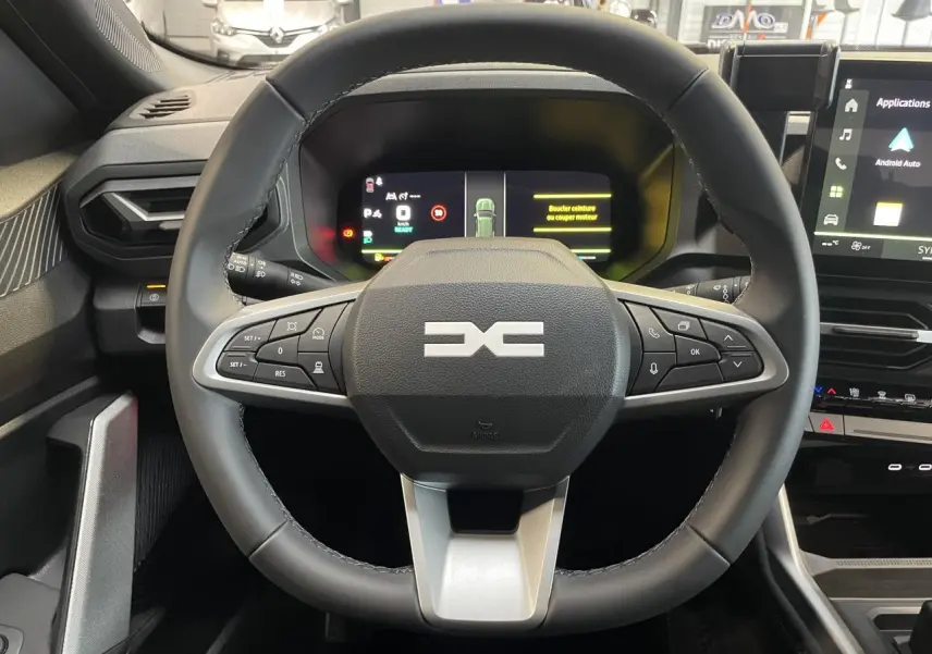Vue intérieure centrée sur le volant noir du Dacia Bigster 2026 avec combiné numérique et écran tactile à droite.