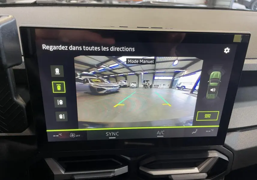 Écran tactile intérieur affichant la caméra multivues du Dacia Bigster gris schiste en mode manuel dans un garage.