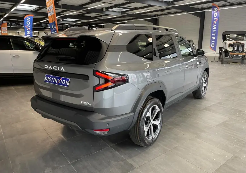 Vue 3/4 arrière droite du Dacia Bigster gris schiste avec jantes alliage et signature lumineuse LED distinctive.