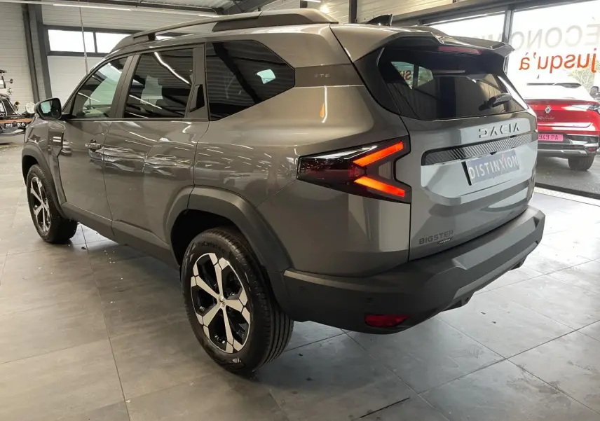 Vue 3/4 arrière droite du Dacia Bigster gris schiste avec feux arrière LED en forme de flèche et jantes alliage 18 pouces.