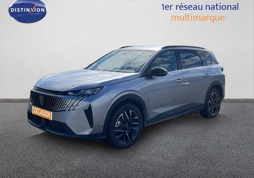 Peugeot 5008 Hybrid gris Artense métal en 3/4 avant droit, avec calandre distinctive et jantes noires bicolores.