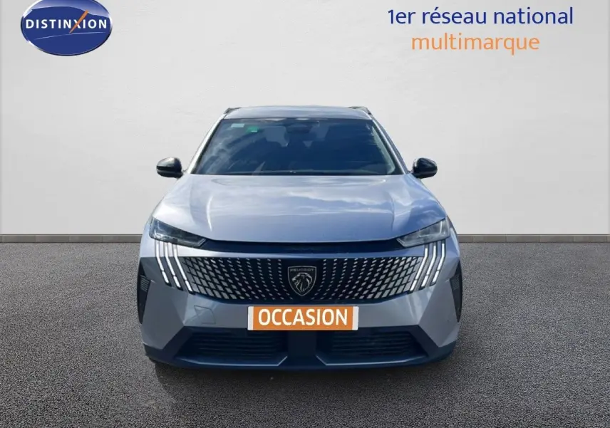 Vue avant d’un Peugeot 5008 Hybrid 145ch gris Artense métal avec calandre distinctive et feux LED verticaux.