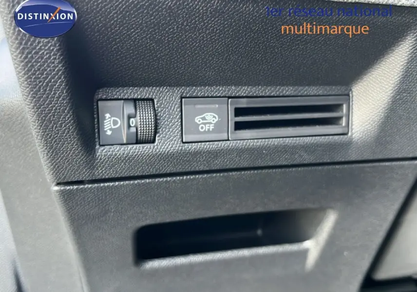 Détail intérieur montrant les commandes de réglage des phares et la ventilation sur un Peugeot 5008 gris Artense 2025.