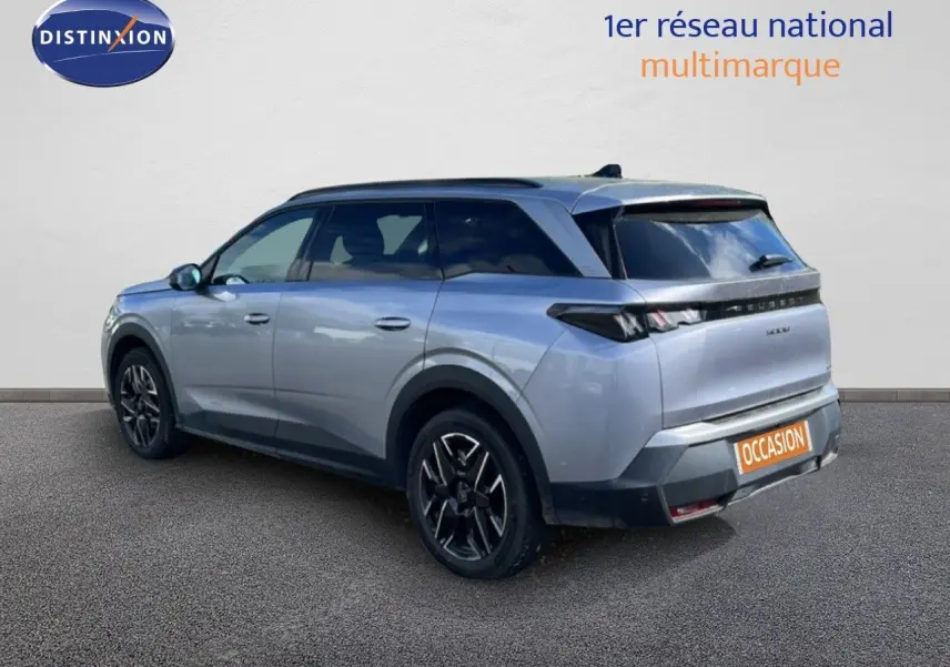 Peugeot 5008 Hybrid gris Artense métal, vue 3/4 arrière droit, jantes noires et toit panoramique visible.
