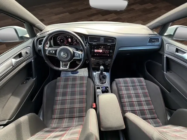 Vue intérieure centrée sur le volant cuir et alu avec coutures rouges de la Volkswagen Golf GTI Performance blanche de 2019.