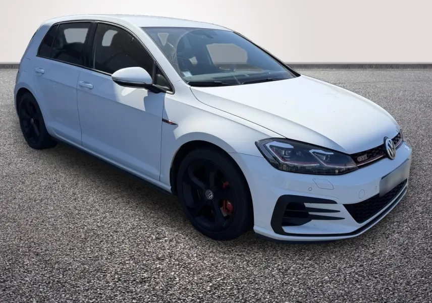 Vue arrière d’une Volkswagen Golf GTI Performance blanche, avec double sortie d’échappement et toit noir contrasté.