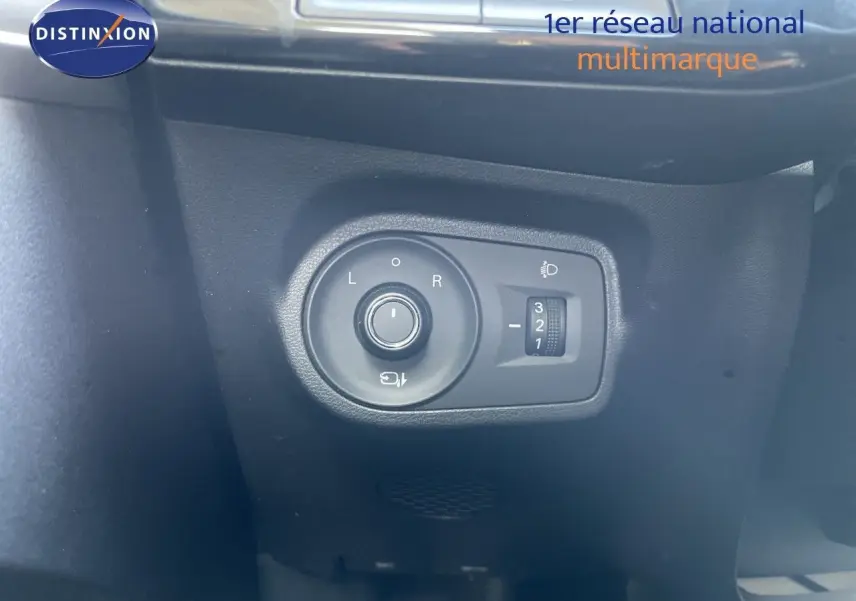 Gros plan sur le bouton de réglage des rétroviseurs et des phares dans l’habitacle noir du MG3 2025.