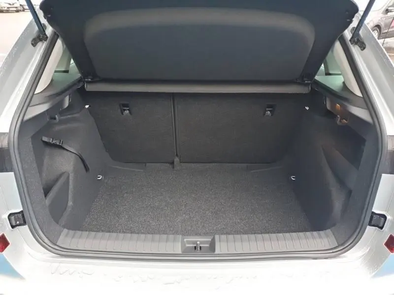 Coffre ouvert vu de l'arrière d'un Skoda Kamiq gris diamant métallisé, espace de chargement propre et vide.