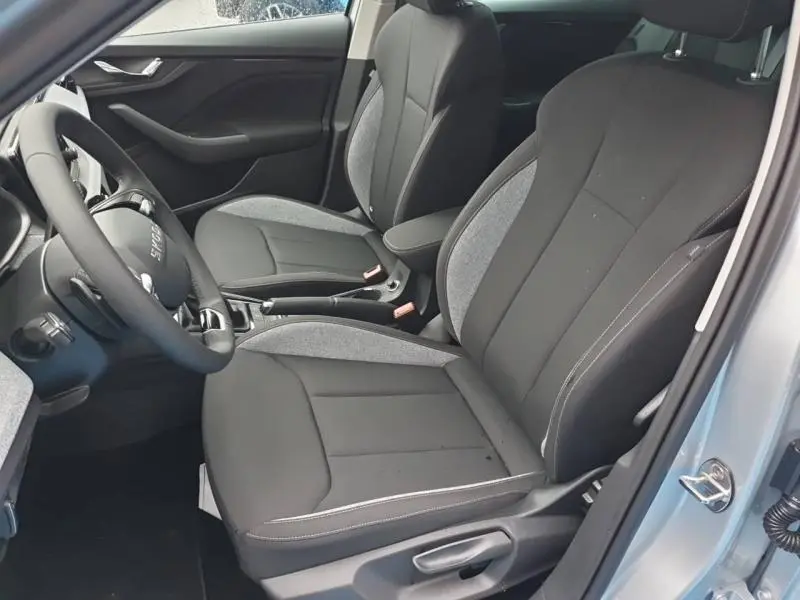 Vue intérieure côté gauche du Skoda Kamiq 2025, sièges tissu noir et gris avec accoudoir central.