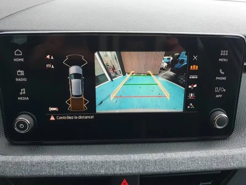 Écran tactile intérieur montrant la caméra de recul et l’aide au stationnement du Skoda Kamiq gris diamant 2025.