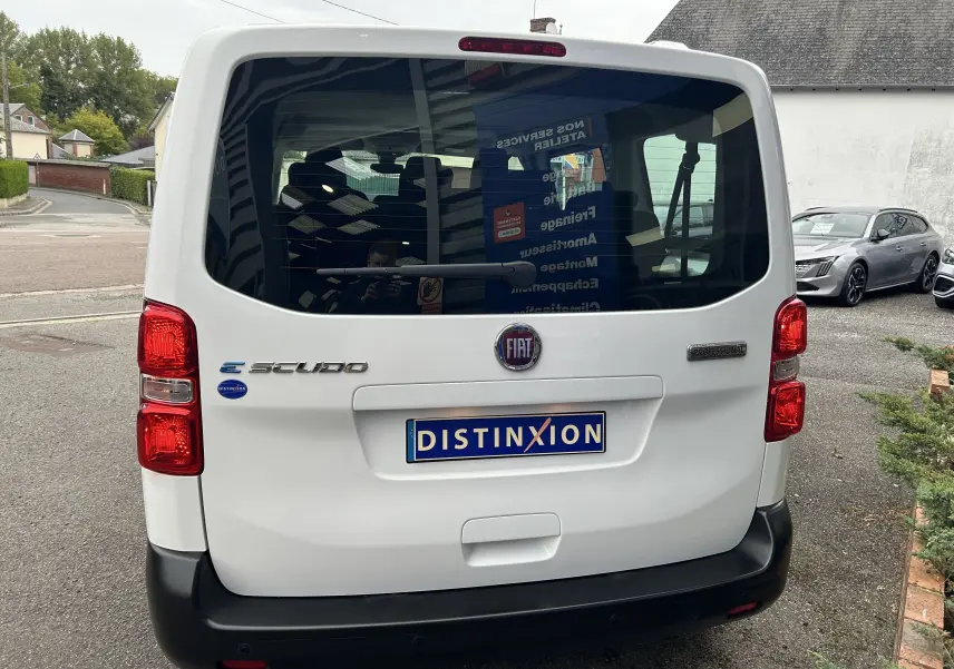 Vue arrière d'un FIAT Scudo Combi blanc électrique avec logo Distinxion sur le hayon et feux rouges verticaux.