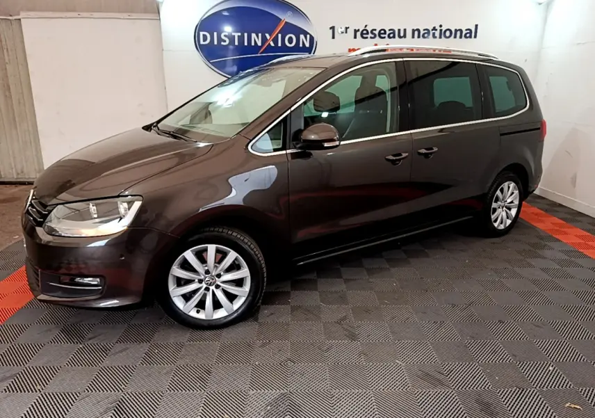 Volkswagen Sharan marron vue de profil côté gauche dans un showroom avec jantes alliage et vitres teintées.