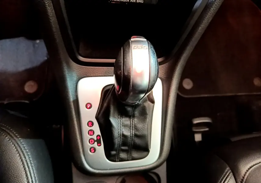 Le levier de vitesses DSG noir et argenté du Volkswagen Sharan 2017 vu de dessus dans un intérieur sombre.