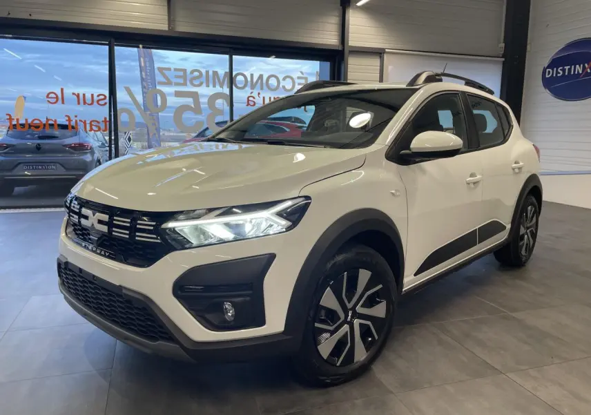 Dacia Sandero Stepway blanc glacier en 3/4 avant droit, avec calandre noire et jantes bicolores.