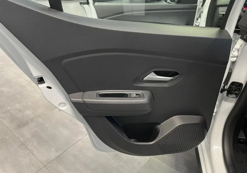 Porte arrière droite ouverte de la Dacia Sandero Stepway 2025 blanc glacier, avec panneau intérieur noir et commande de vitre.