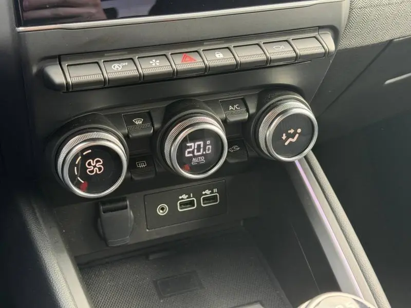 Gros plan sur les commandes de climatisation et les ports USB de la Renault Clio 1.0 TCe 90ch Techno, intérieur noir moderne.