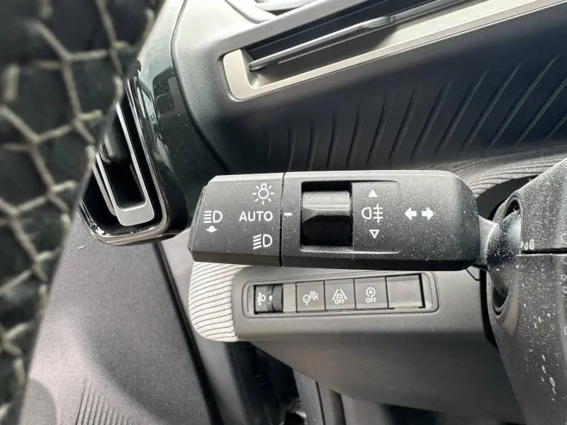 Gros plan sur la commande des feux à gauche du volant dans l'habitacle gris Mercury de la Citroën C3 2025.