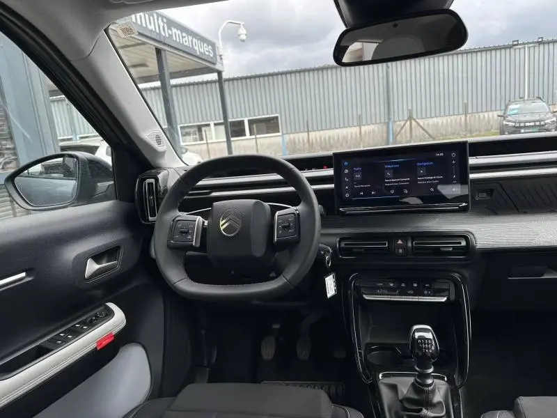 Intérieur de la Citroën C3 1.2 Turbo 100ch MAX 2025, vue du poste de conduite avec volant, écran tactile et levier de vitesse manuel.