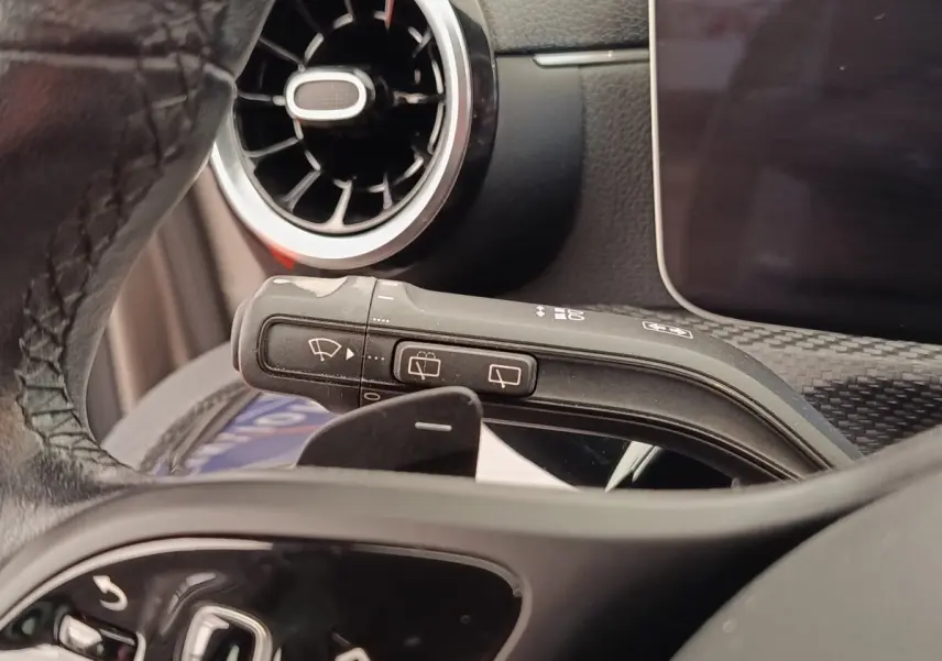 Gros plan sur la commande d’essuie-glace et le volant cuir noir d’une Mercedes Classe A 180 Business Line 2020.