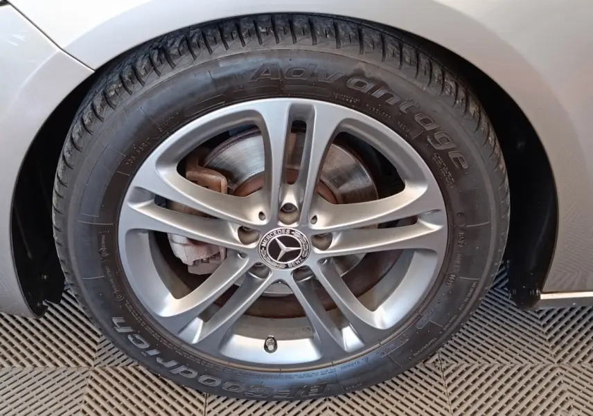 Gros plan sur la roue avant droite gris clair d'une Mercedes Classe A 180 Business Line avec jante alliage.