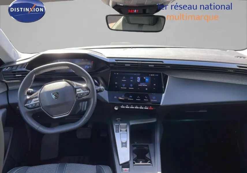 Vue intérieure avant du tableau de bord et volant gris noir de la Peugeot 308 SW Hybrid 2025 avec écran tactile central.