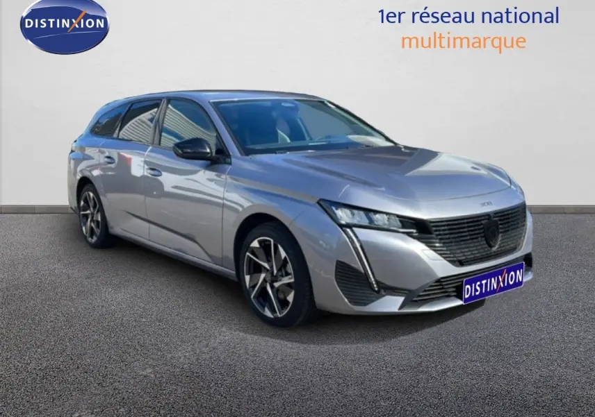 Peugeot 308 SW gris Artense métal vue 3/4 avant droit, avec calandre noire et jantes alliage bicolores.
