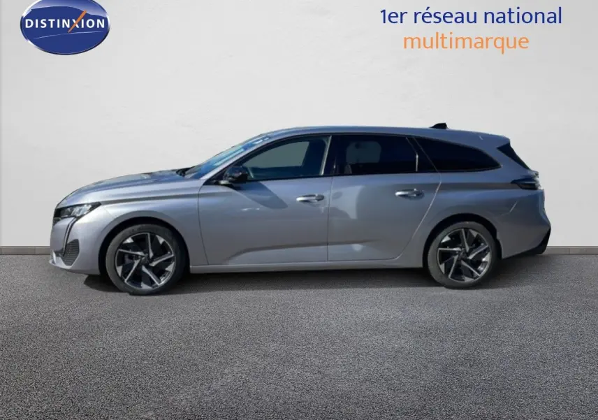 Profil latéral droit d’une Peugeot 308 SW gris Artense métal de 2025 avec jantes alliage bicolores et toit noir.