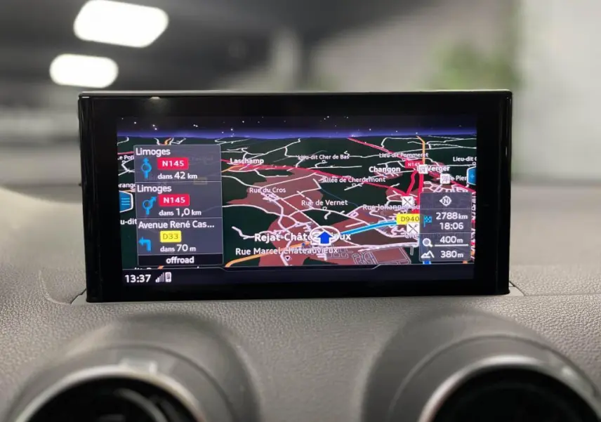 Écran central de navigation de l'Audi Q2 2022 affichant un itinéraire avec carte détaillée et indications routières.