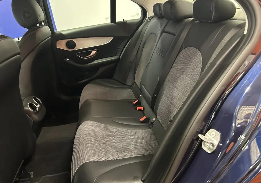Vue intérieure arrière côté droit de la Mercedes Classe C 200d bleu, sièges mixtes cuir et tissu gris avec appuie-têtes.