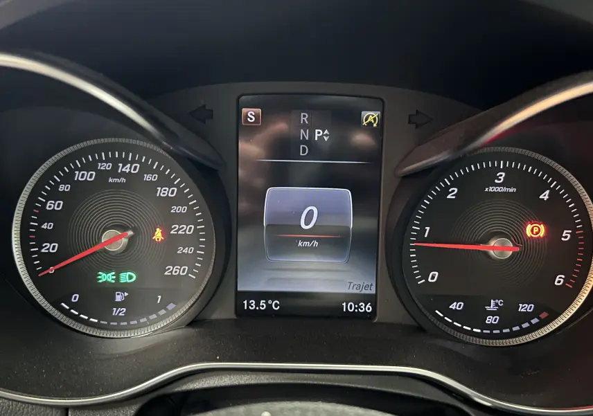 Vue rapprochée du tableau de bord de la Mercedes Classe C 200d bleu, affichant vitesse à 0 km/h et compte-tours au ralenti.